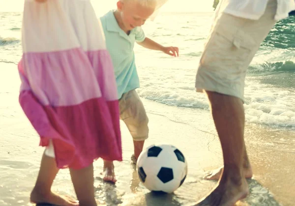 Familie spielt Fußball am Strand — Stockfoto