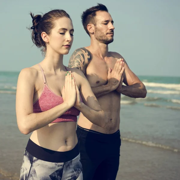 夫妻在海滩上做瑜伽 — 图库照片