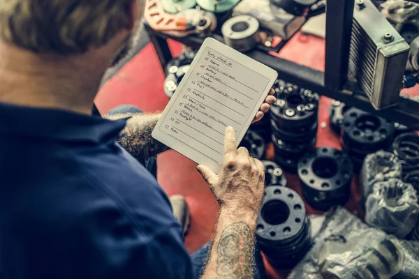 Meccanico dell'automobile facendo uso della compressa digitale — Foto Stock