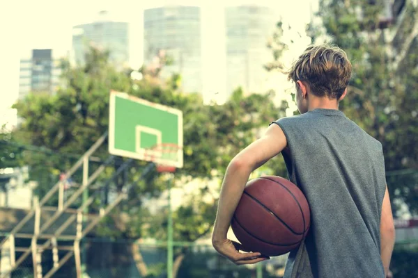 Junge hält Basketballball — Stockfoto