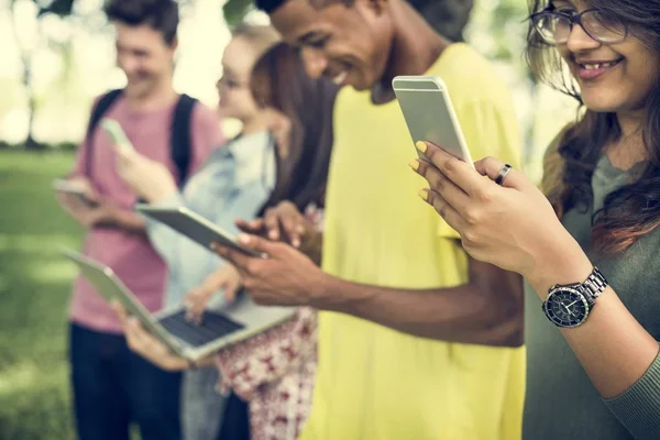 Amici che camminano e utilizzano dispositivi digitali — Foto Stock