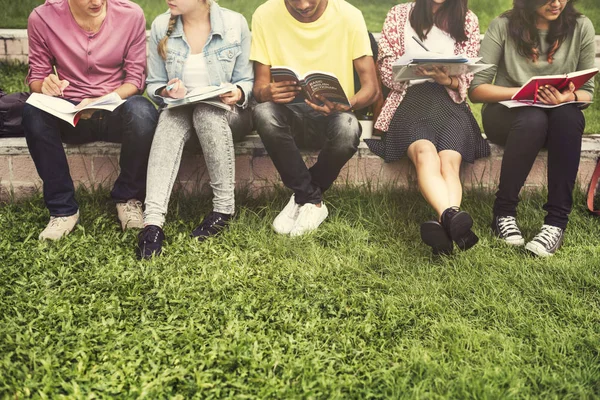 Olika studenter sitta på park — Stockfoto