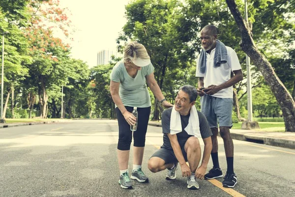 Amigos seniores fazendo jogging no parque — Fotografia de Stock