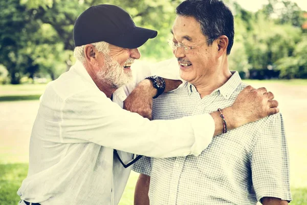 Старші друзі розмовляють і сміються — стокове фото