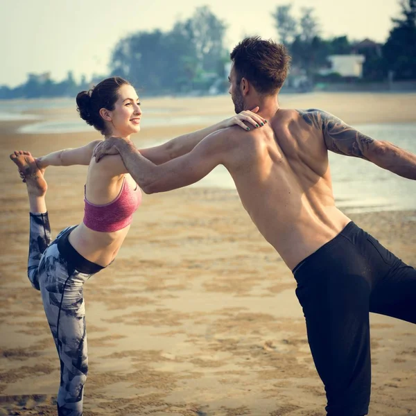 Пара робить йогу на пляжі — стокове фото