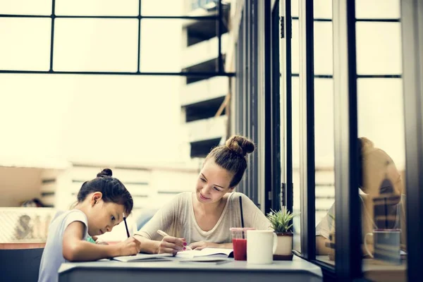 Жінка і дівчина роблять домашнє завдання — стокове фото