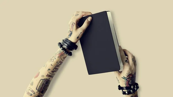 Notebook in hands in tattoos