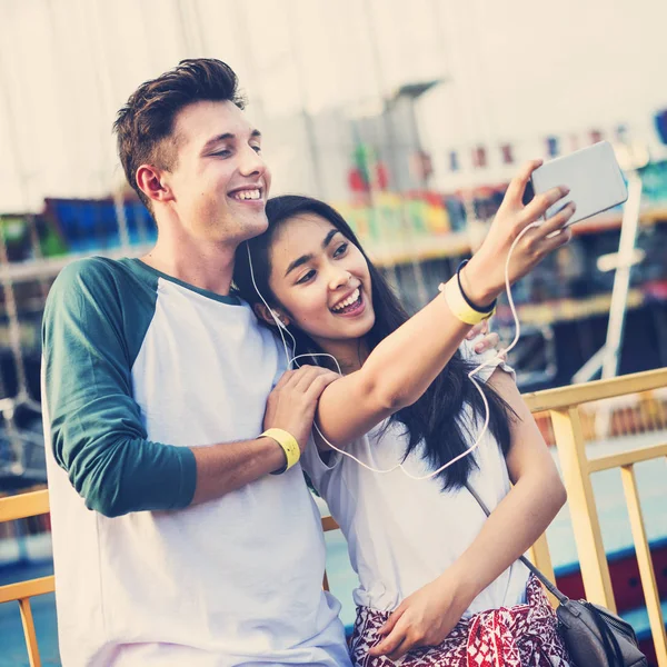 Pareja haciendo selfie en parque de atracciones — Foto de Stock