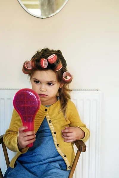 Маленькая девочка с бигуди на волосах — стоковое фото