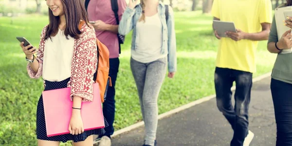 Amici che camminano e utilizzano dispositivi digitali — Foto Stock