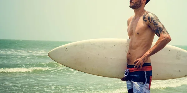 Schöner sportlicher Mann mit Surfbrett — Stockfoto