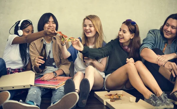Jonge vrienden eten van pizza — Stockfoto