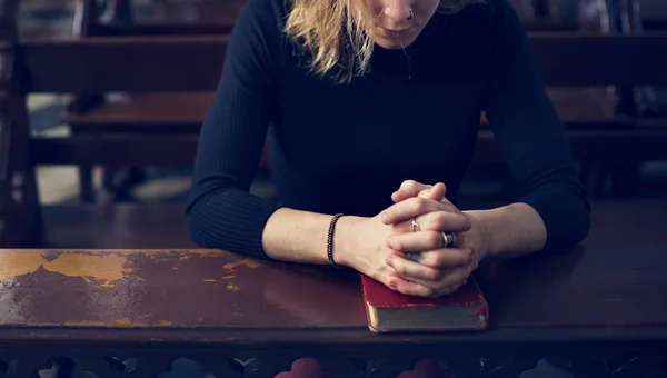 Kobieta siedzi w kościele — Zdjęcie stockowe