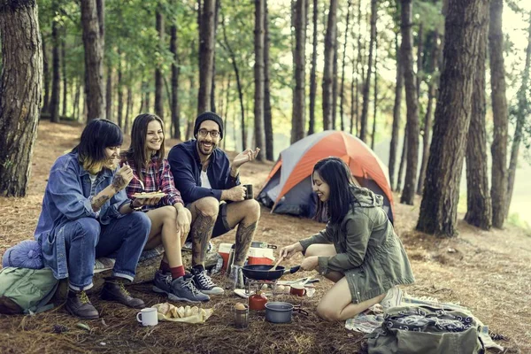 Amigos comendo alimentos no acampamento — Fotografia de Stock