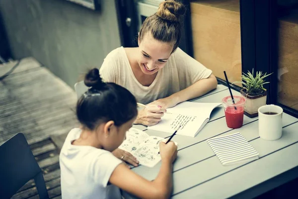 Mujer y chica haciendo tarea — Foto de Stock