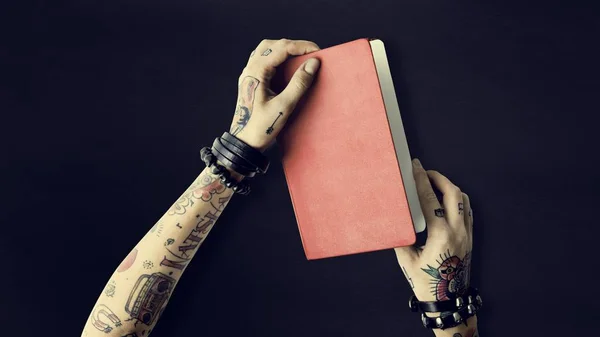 Notebook in hands in tattoos — Stock Photo, Image