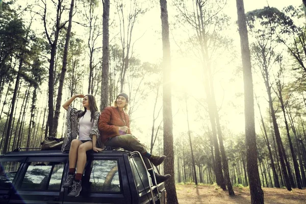 Casal sentado no carro na floresta — Fotografia de Stock