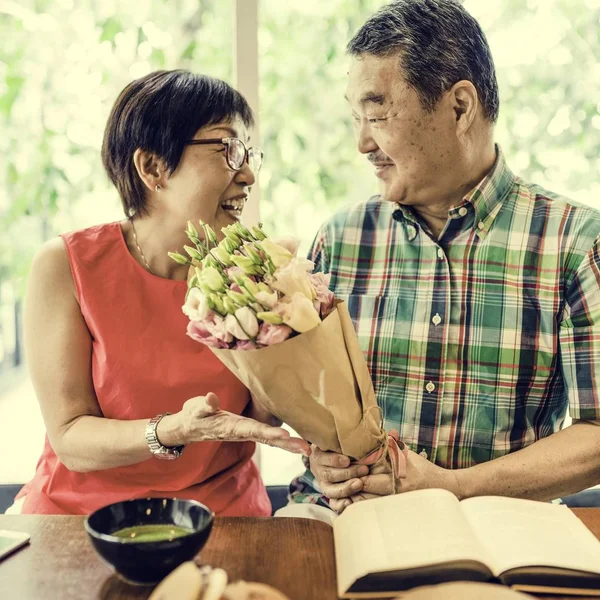 Hombre da flores a una mujer — Foto de Stock