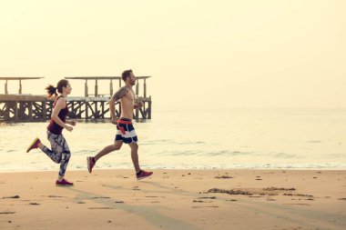 Sportif çift sahilde çalıştıran