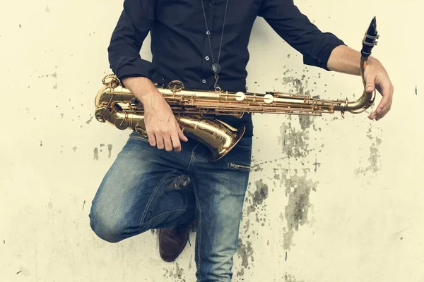 Джаззман держит саксофон — стоковое фото