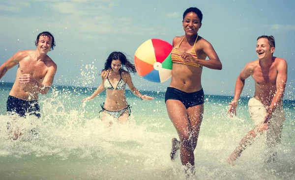 Люди играют с мячом на пляже — стоковое фото