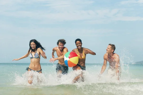 Menschen spielen mit Ball am Strand — Stockfoto