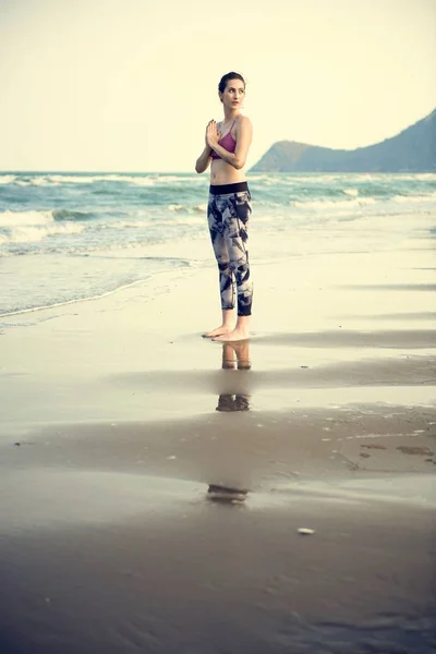 Женщина занимается йогой на пляже — стоковое фото