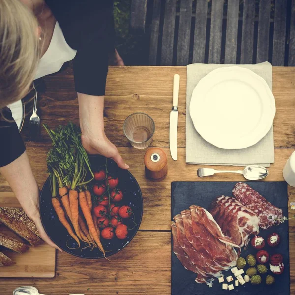 Frau bereitet Tisch für Abendessen vor — Stockfoto