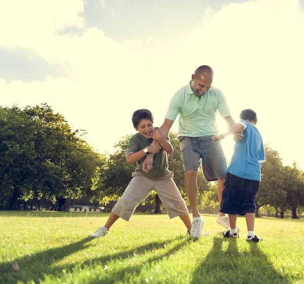 Far och små pojkar spelar utomhus — Stockfoto