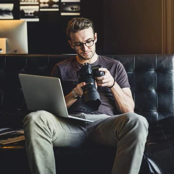 Fotograaf op zoek naar foto's op de camera — Stockfoto