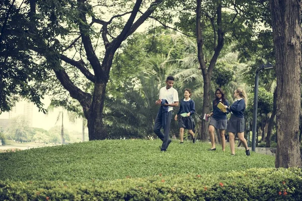 緑豊かな公園で歩いている学生 — ストック写真