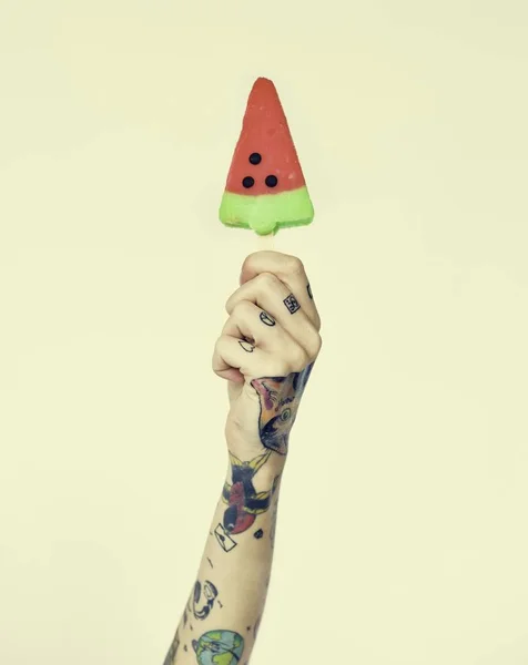 hand in tattoos holds ice-cream