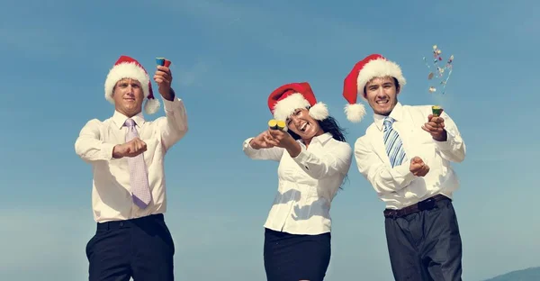 Geschäftskollegen mit Weihnachtsmützen am Strand — Stockfoto