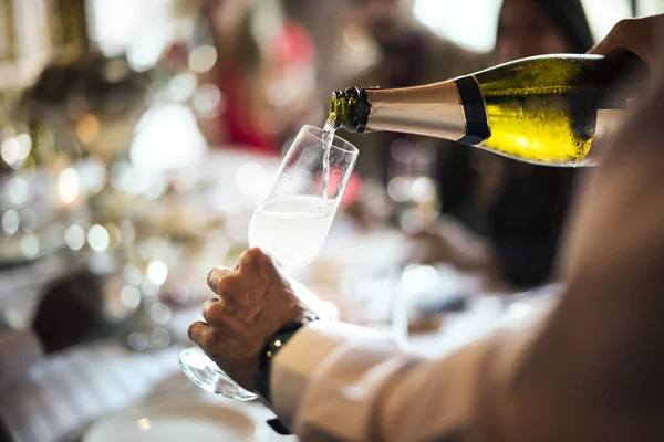 Der Kellner gießt Champagner in ein Glas — Stockfoto