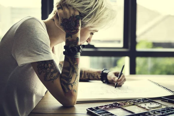Γυναίκα με τατουάζ σχεδίασης — Φωτογραφία Αρχείου