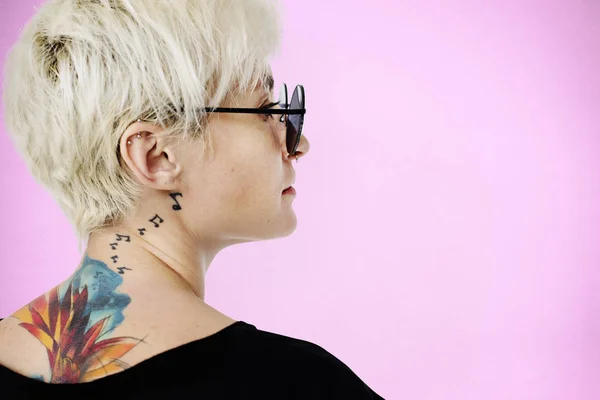 Kvinna med tatueringar poserar i studio — Stockfoto
