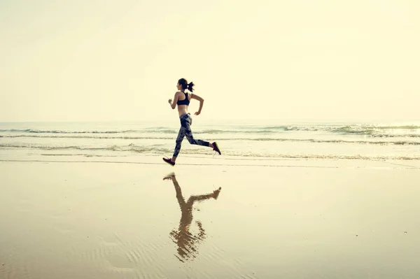 Αθλητική γυναίκα τρέχει στην παραλία — Φωτογραφία Αρχείου