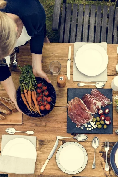 Kvinna som förbereder bord för middag — Stockfoto