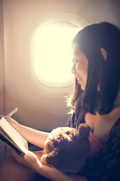 Woman Reading Book in Plane