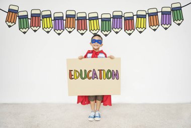 Süper kahraman çocuk elinde karton ile