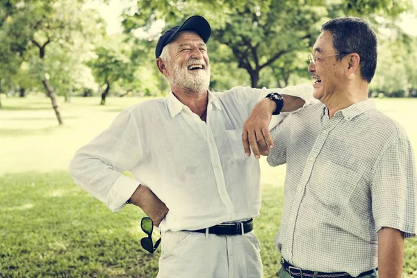 Mature Friends talking at park — Stock Photo, Image