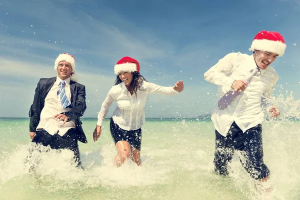 Коллеги по бизнесу в Santa Hats on Beach — стоковое фото