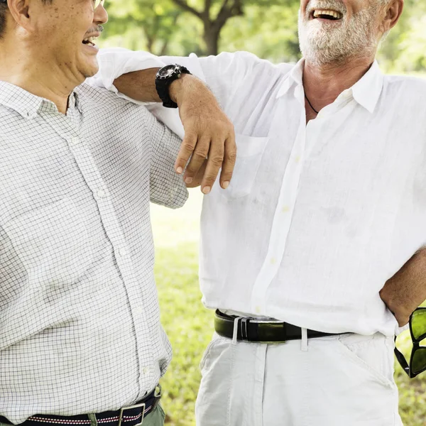 Amigos maduros conversando no parque — Fotografia de Stock