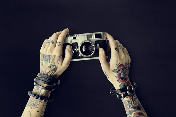 Τα χέρια στα τατουάζ κατέχει φωτογραφική μηχανή φωτογραφιών — Φωτογραφία Αρχείου