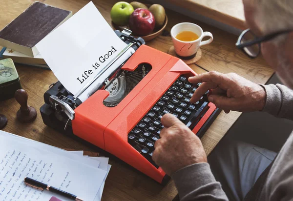 Старший человек, пишущий на пишущей машинке — стоковое фото