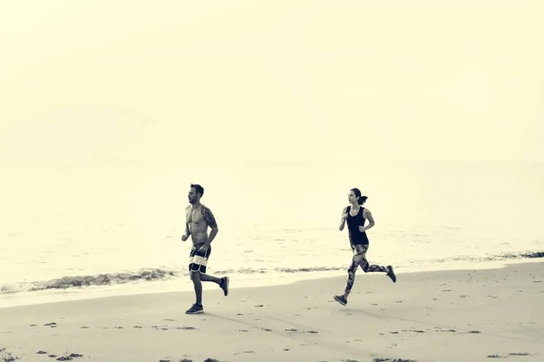 Pareja deportiva Correr en la playa — Foto de Stock