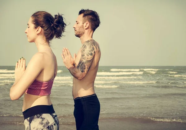 Coppia che fa yoga sulla spiaggia — Foto Stock
