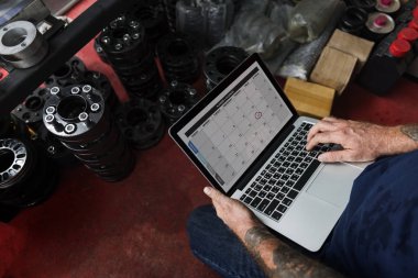 Dizüstü bilgisayar kullanarak garajda araba tamircisi