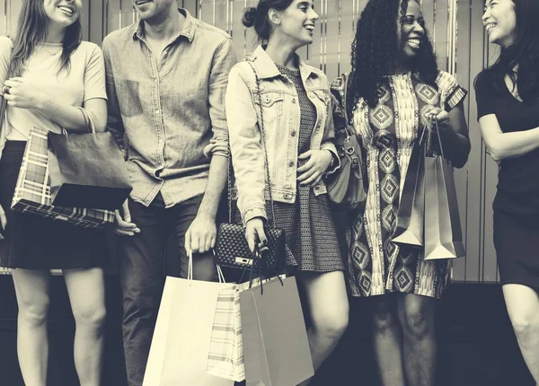 Amigos alegres segurando sacos de compras — Fotografia de Stock