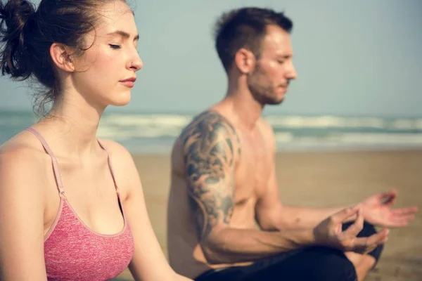 Coppia che fa yoga sulla spiaggia — Foto Stock